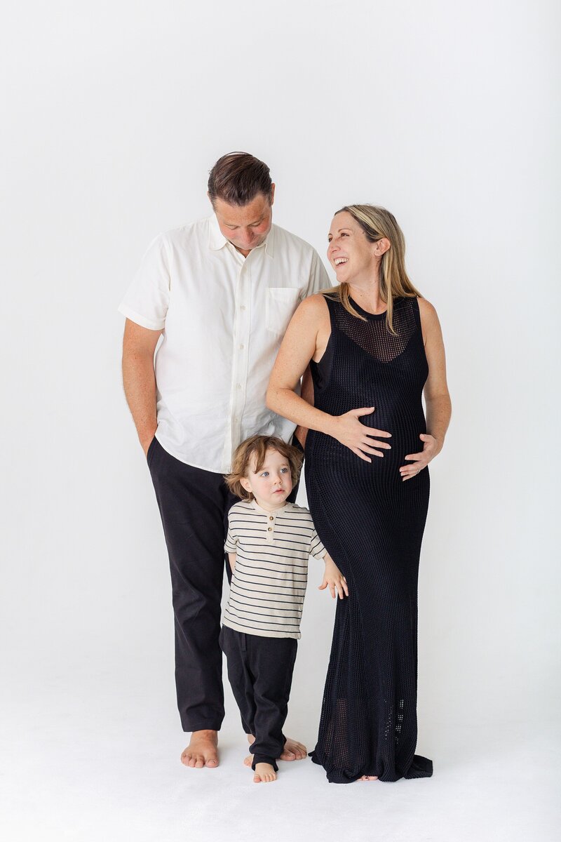modern studio family portrait with black and white attire and white backdrop