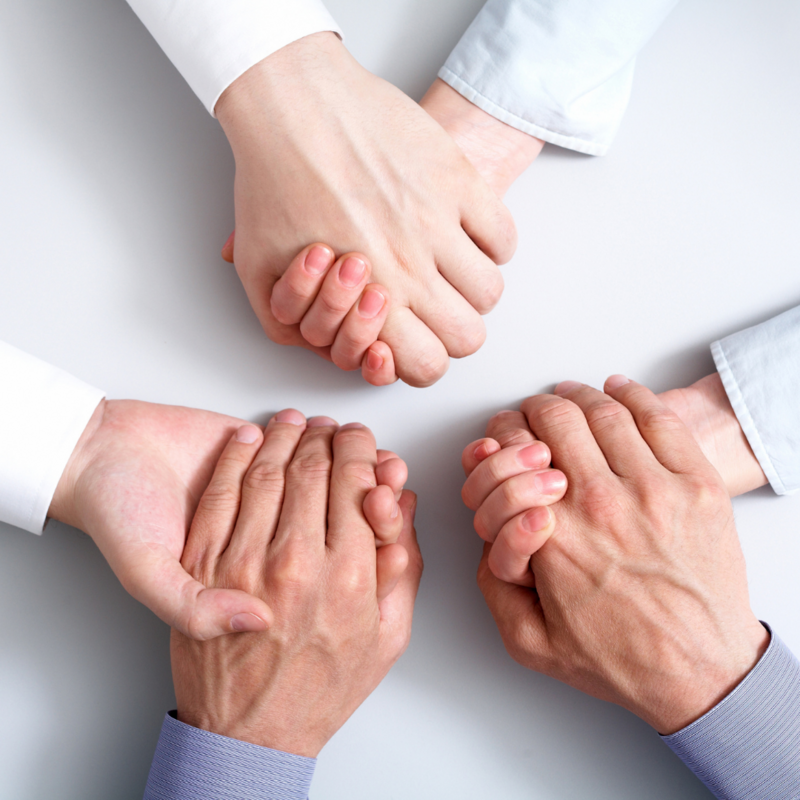 Business coaches supporting entrepreneurs and business owners by holding hands