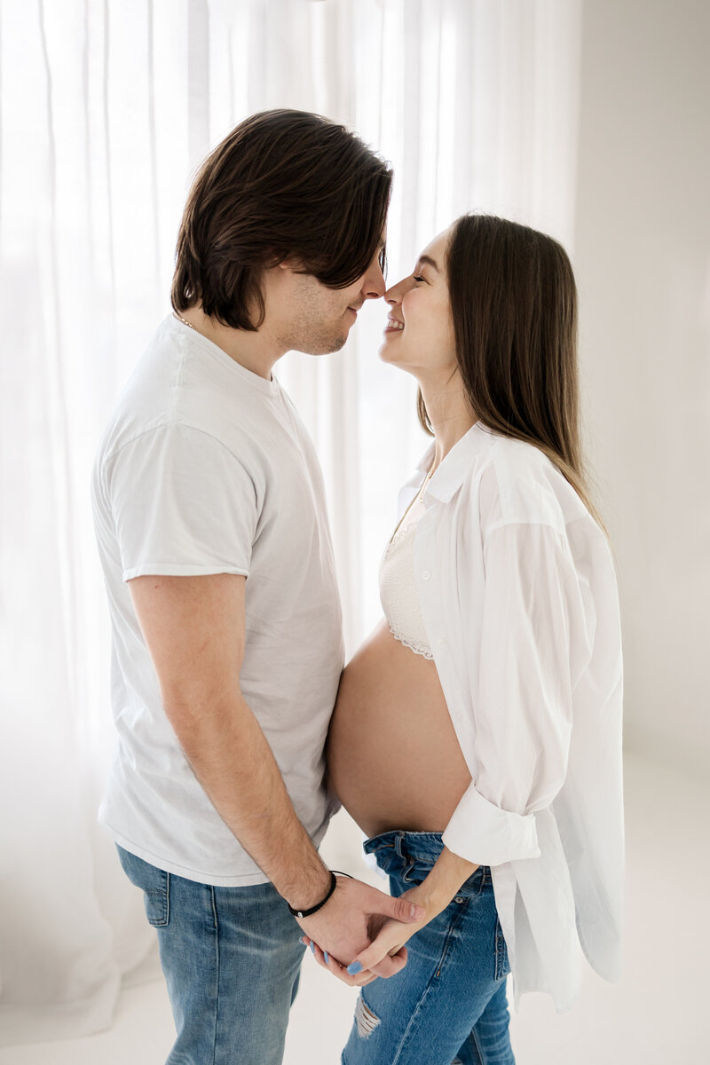 couple pose together during their maternity photoshoot with Blair Davis Photography