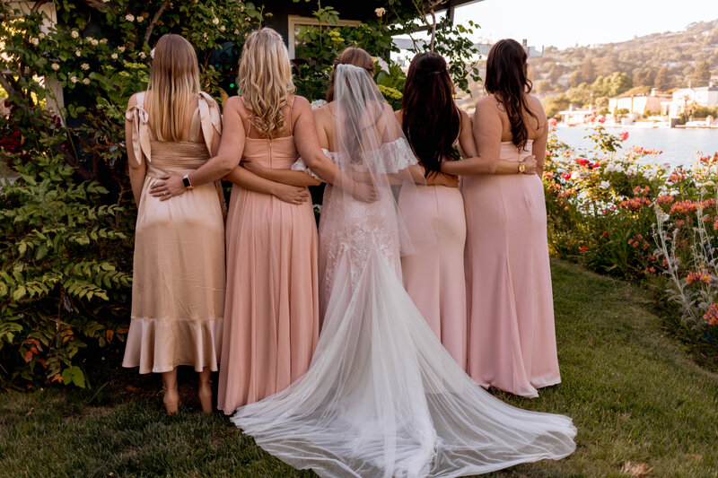 Bridesmaids holdings each other from behind