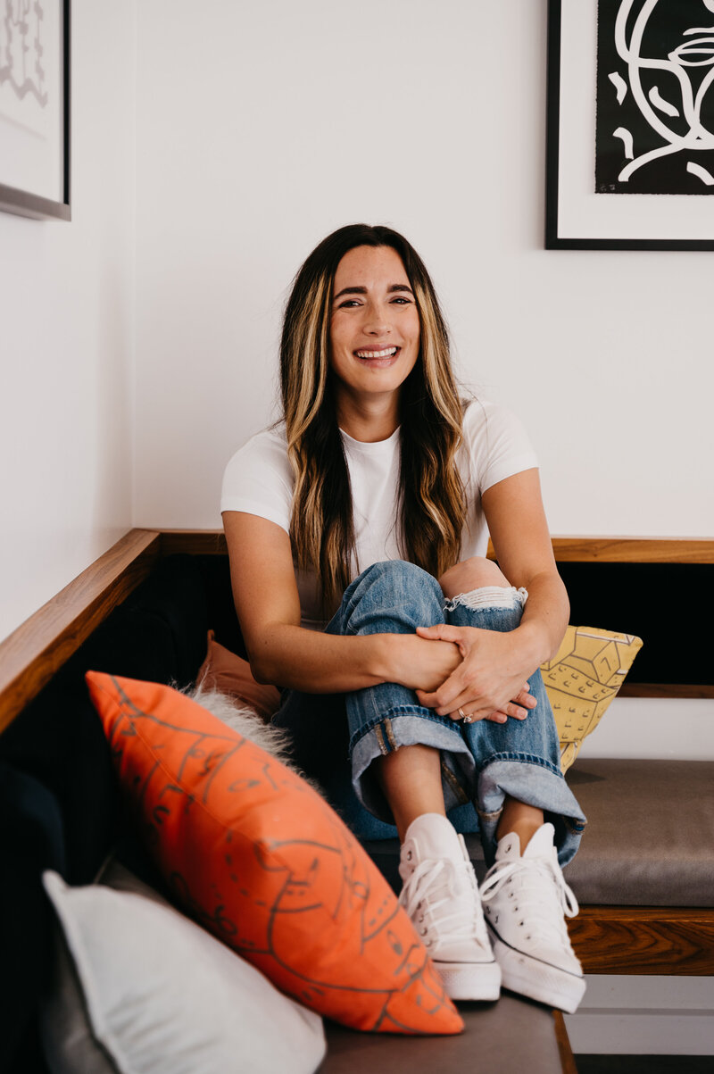 Woman in ripped jeans holding her knees