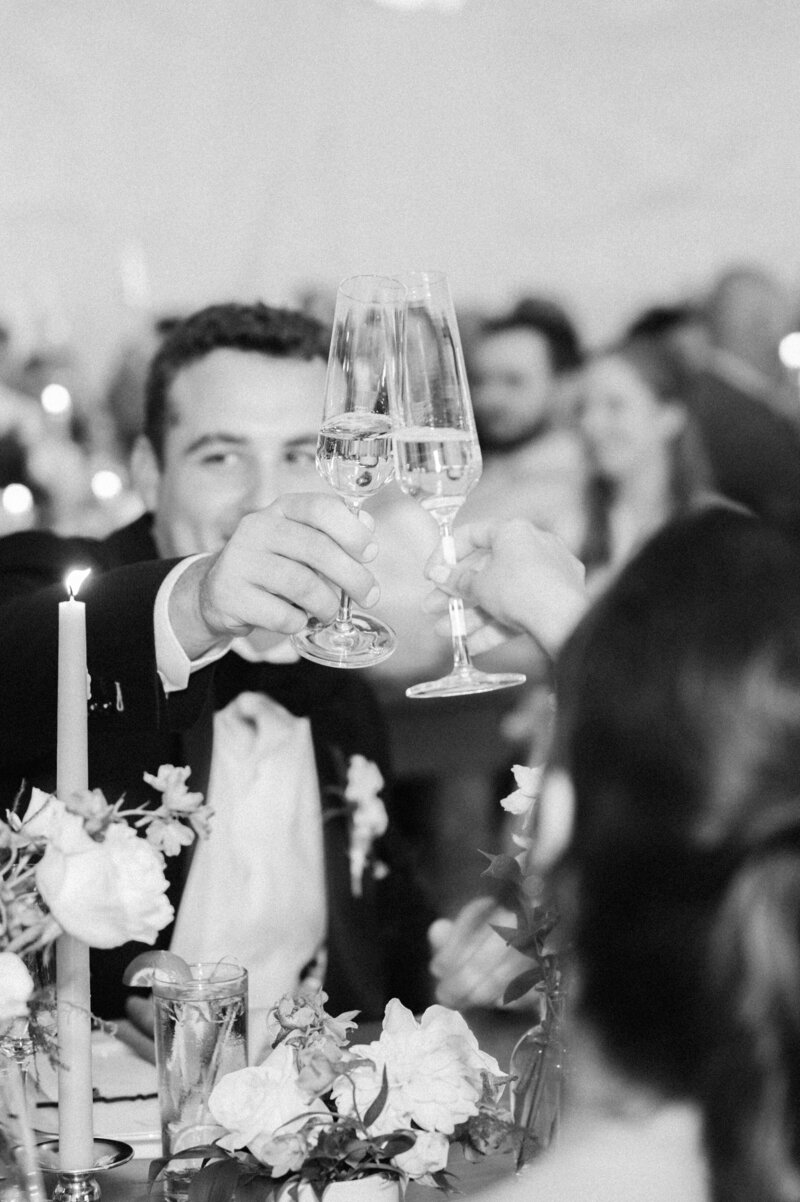 Black and white photo of groom toasting champagne during wedding reception | candid celebration | Cleveland wedding photography