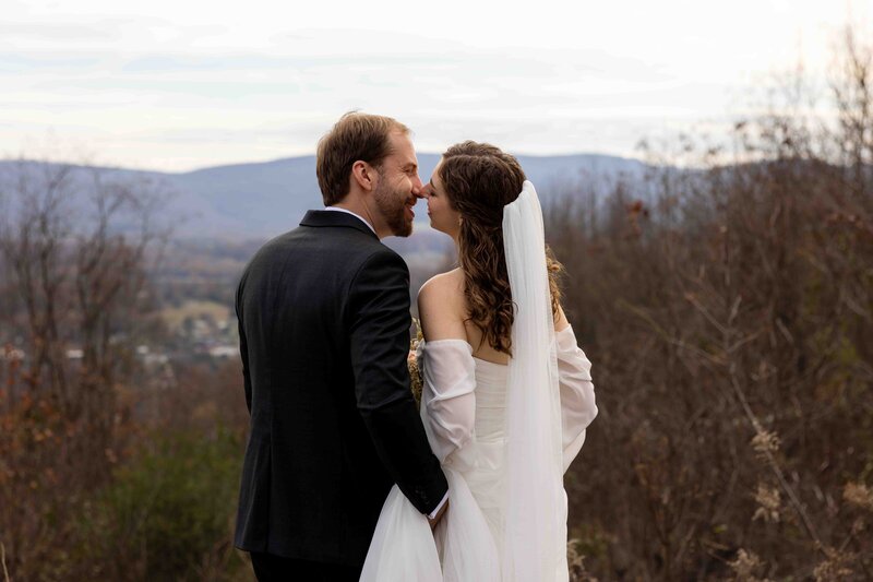 bride and groom kissing with mountains in the background