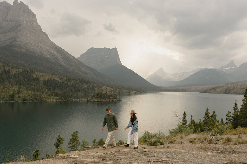 couple walking and smiling at sun point overlook in glacier national park