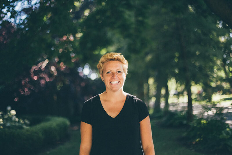 Writer, Sarah Freymuth, smiles for photo outdoors wearing a black v-neck t-shirt