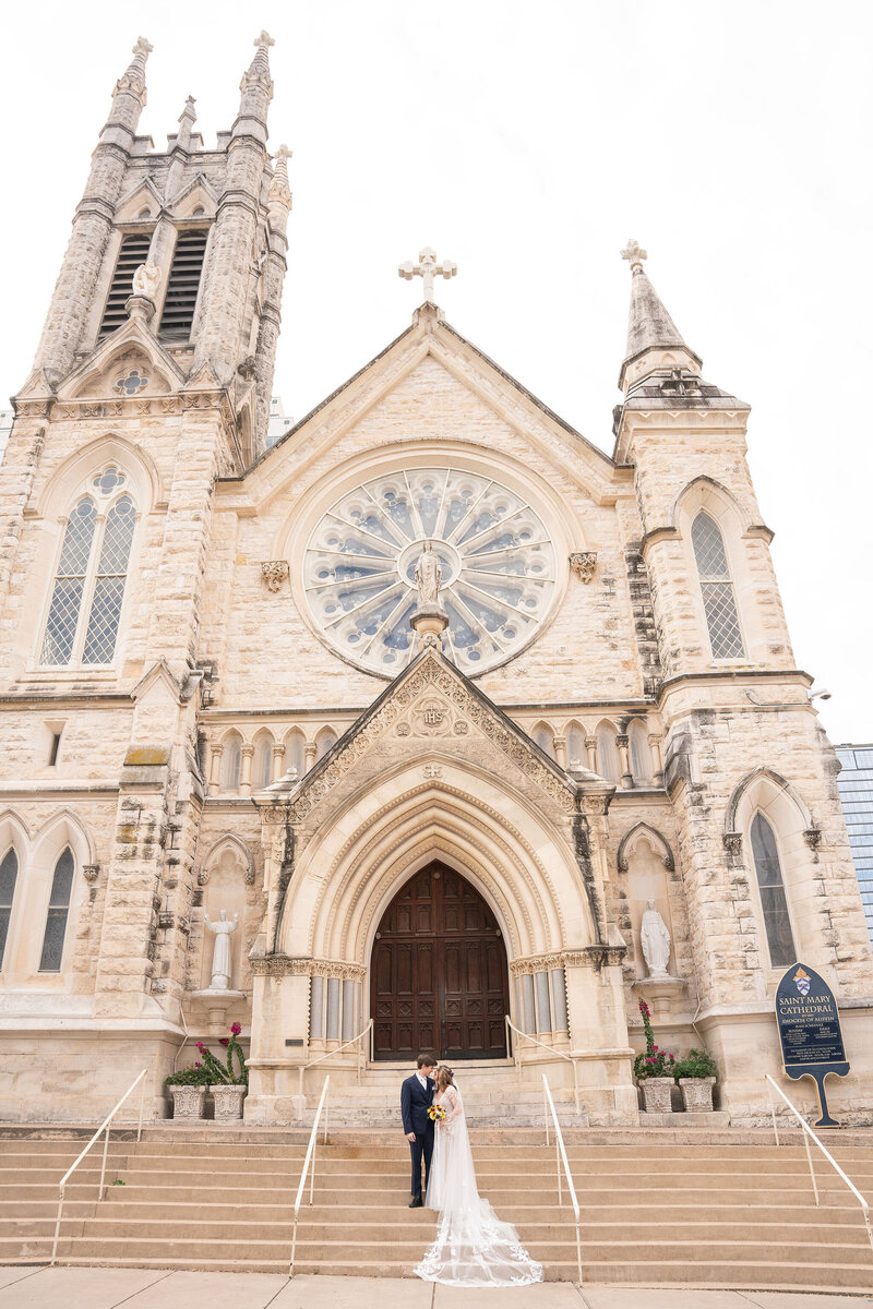 Wedding couple standing in front of St. Mary's Cathedral in Austin Texas.