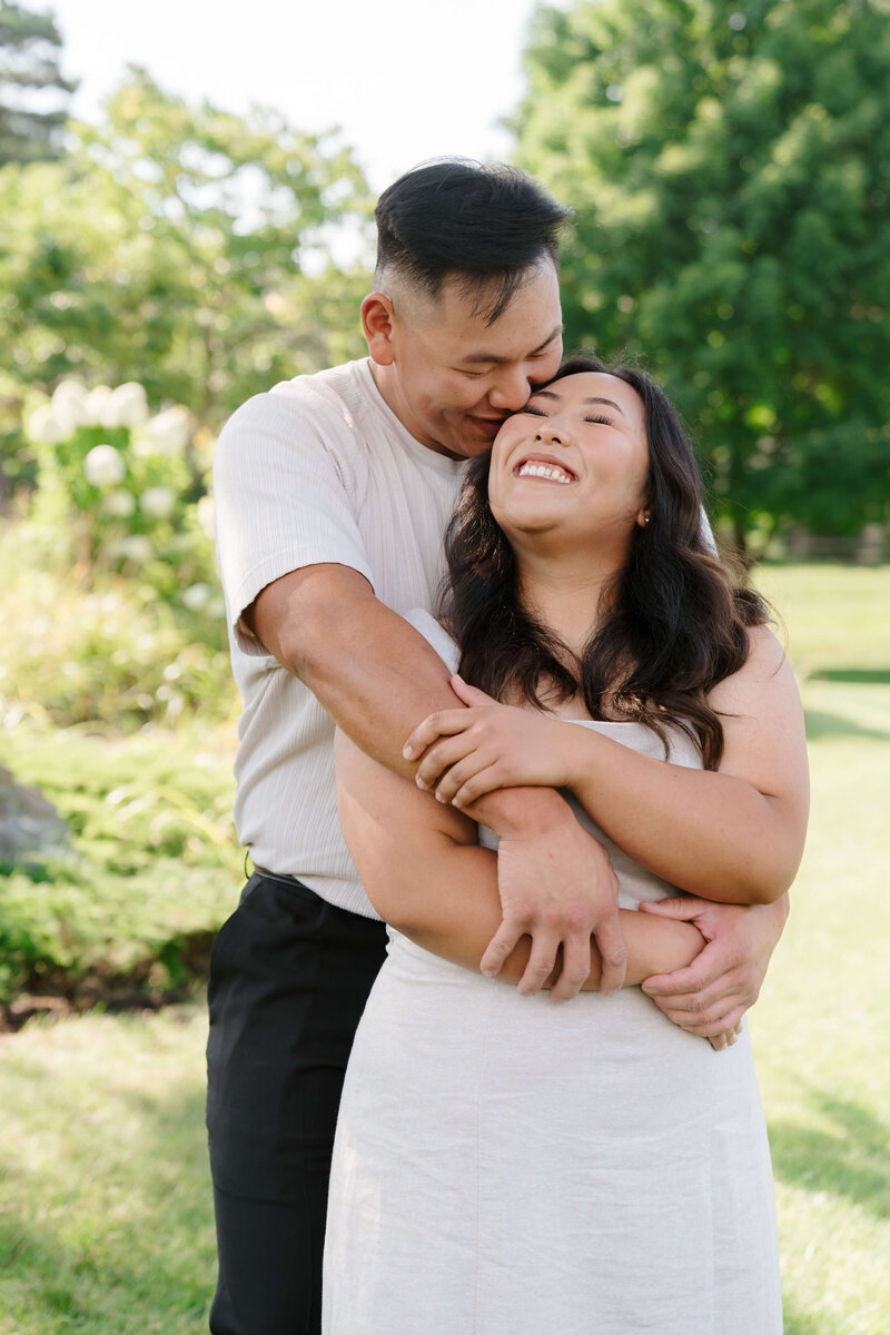 A loving couple shares a hug at Muriel Sahlin Arboretum at Roseville Central Park
