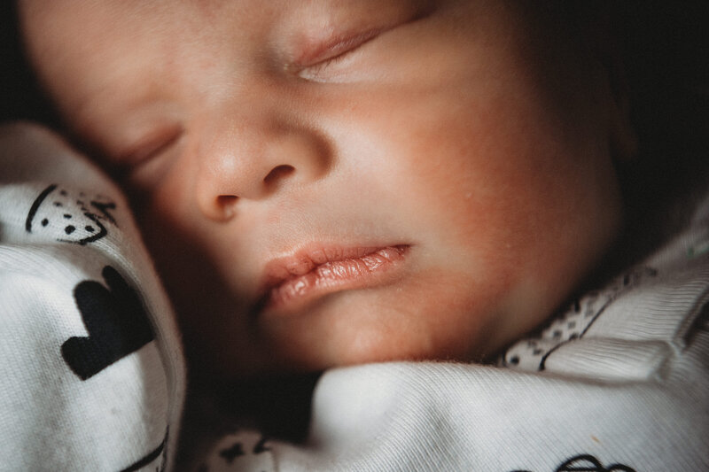Close up of newborn sleeping in bnw outfit