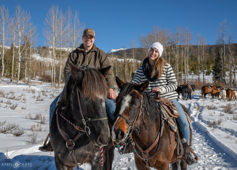 Recently engaged couple enjoy a horseback ride during winter after a surprise proposal on their trip to Colorado at Devil's Thumb Ranch