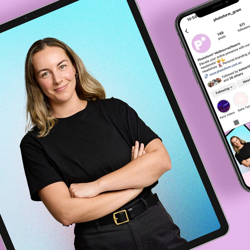 Smiling corporate woman with glasses against pink backdrop.