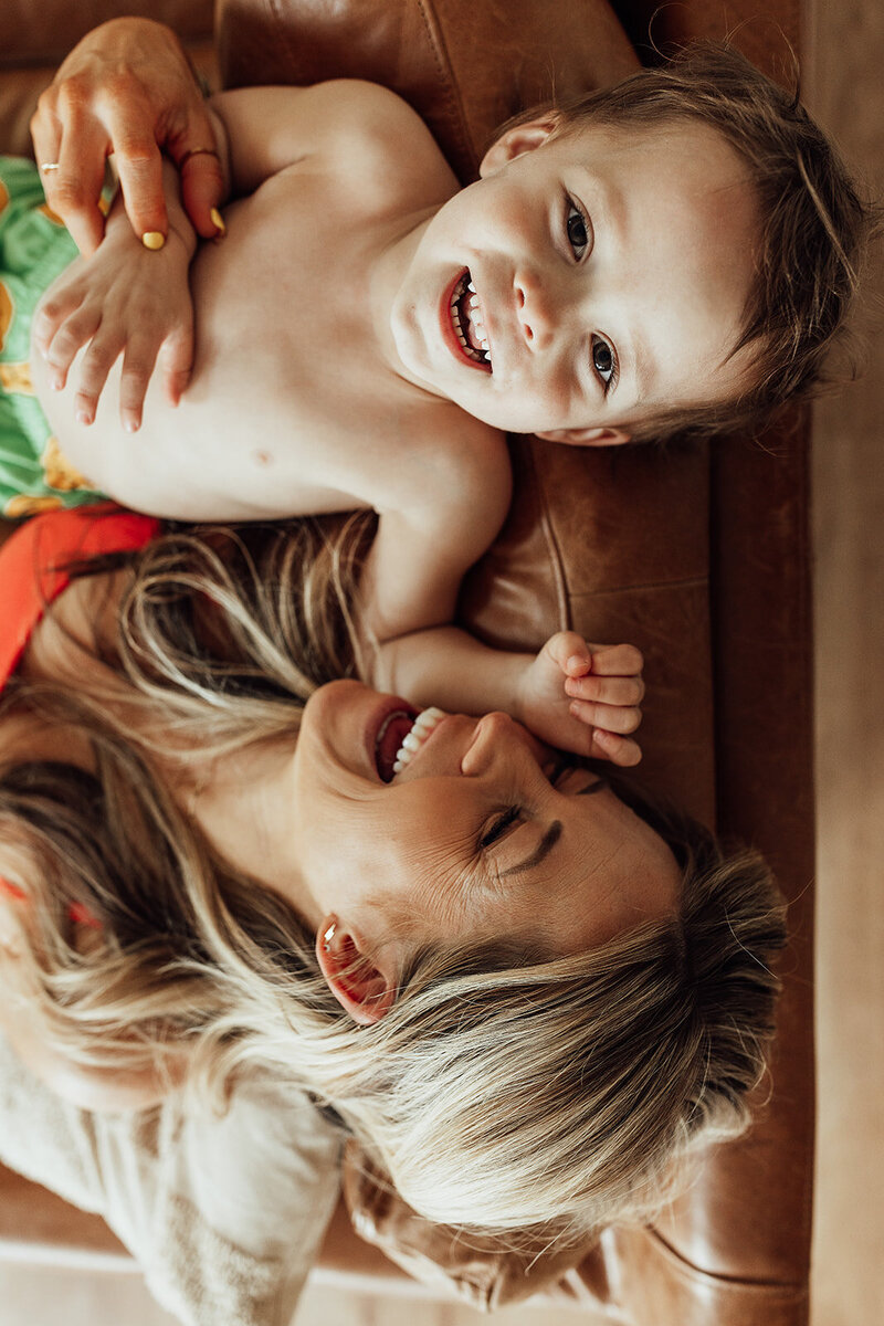 Overhead photo of a mom and her son laughing on the couch