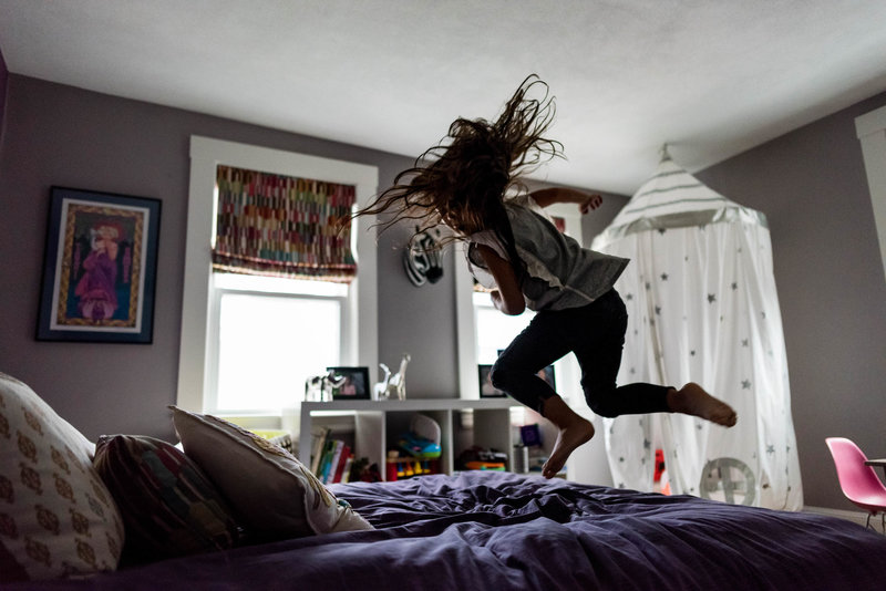 child jumping on her bed