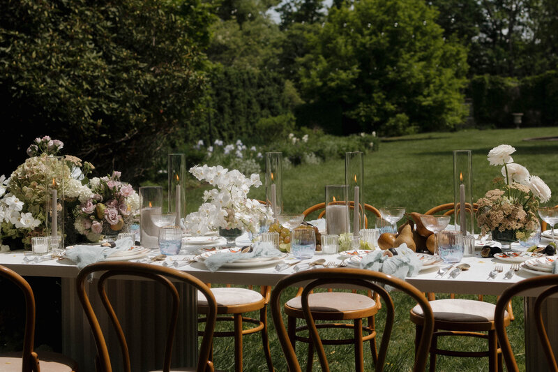 An elegant outdoor wedding reception with floral arrangements and candlelit table settings, perfect for fine art wedding photography.