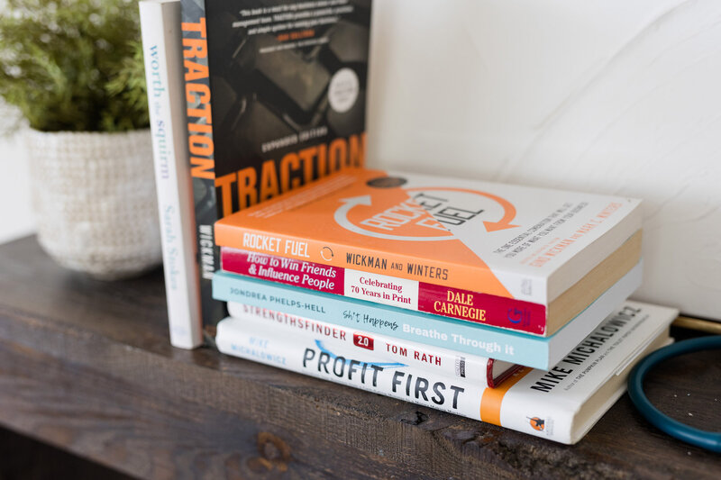 Stacks of business books on a mantle