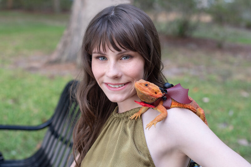 An Orlando senior picture of a girl with her pet dragon being photographed by Khim Higgins Photography.