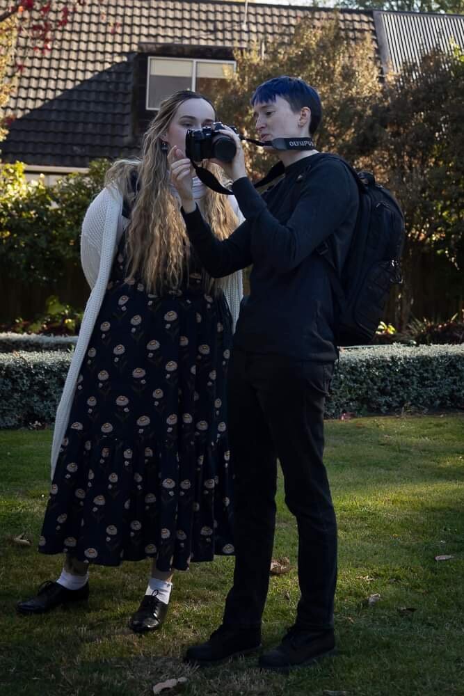 candid photo of photographer River Dantzler showing their camera to a woman during an individual photo session