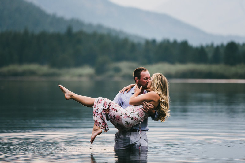 man holding woman in arms at glacier national park