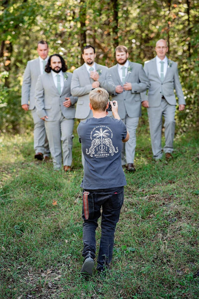 Behind the scenes photo of a videographer documenting groomsmen at a wedding