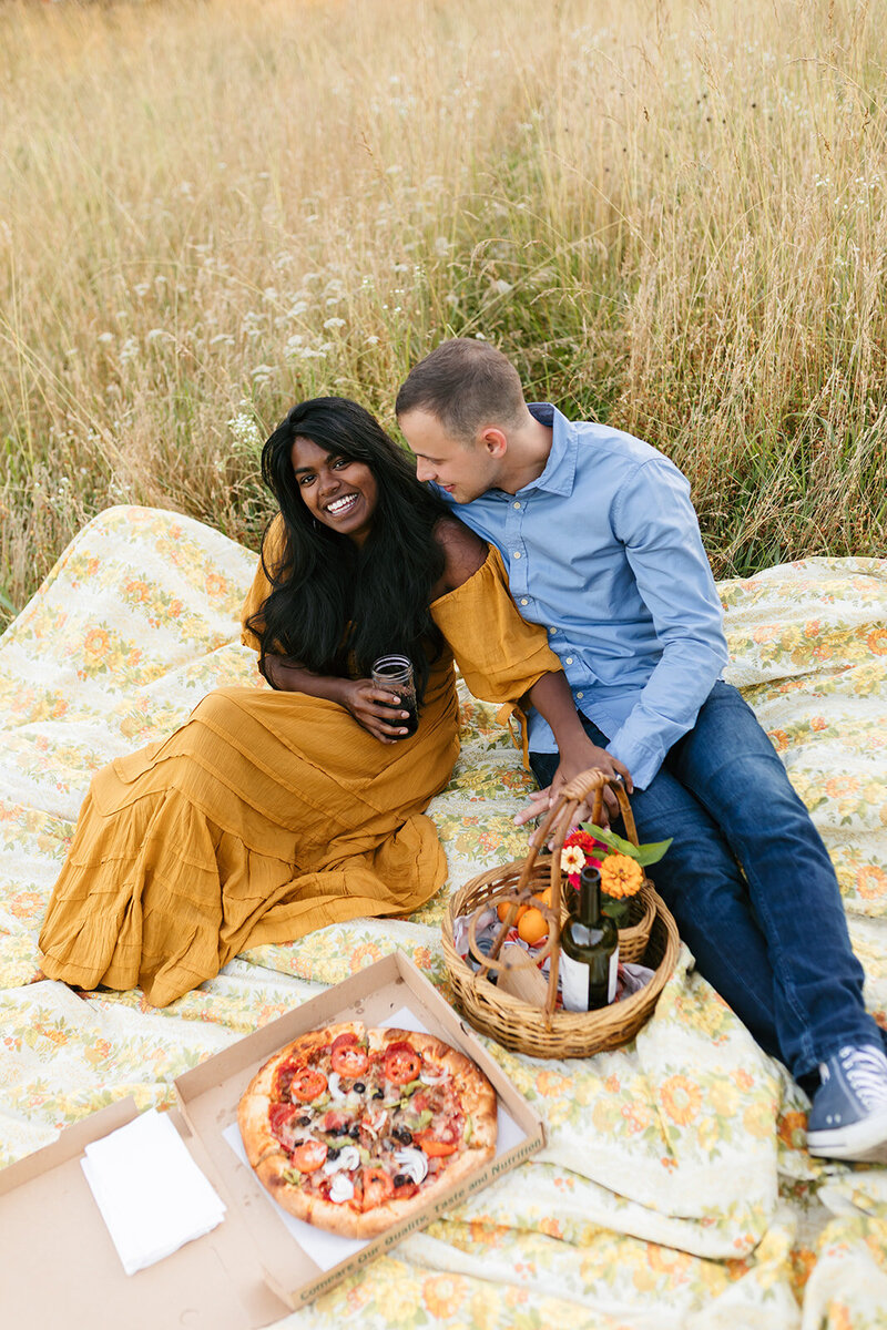Man and woman at warm, picnic engagement photo session