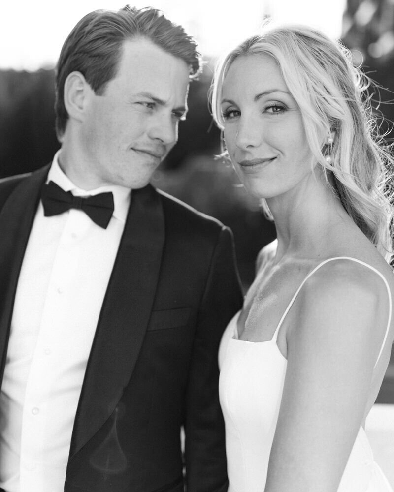 This intimate close-up photograph captures the groom lovingly looking at the bride as she gazes into the camera on a beautiful evening at the Banff Springs Hotel. The elegant setting and their tender connection create a moment of timeless romance.