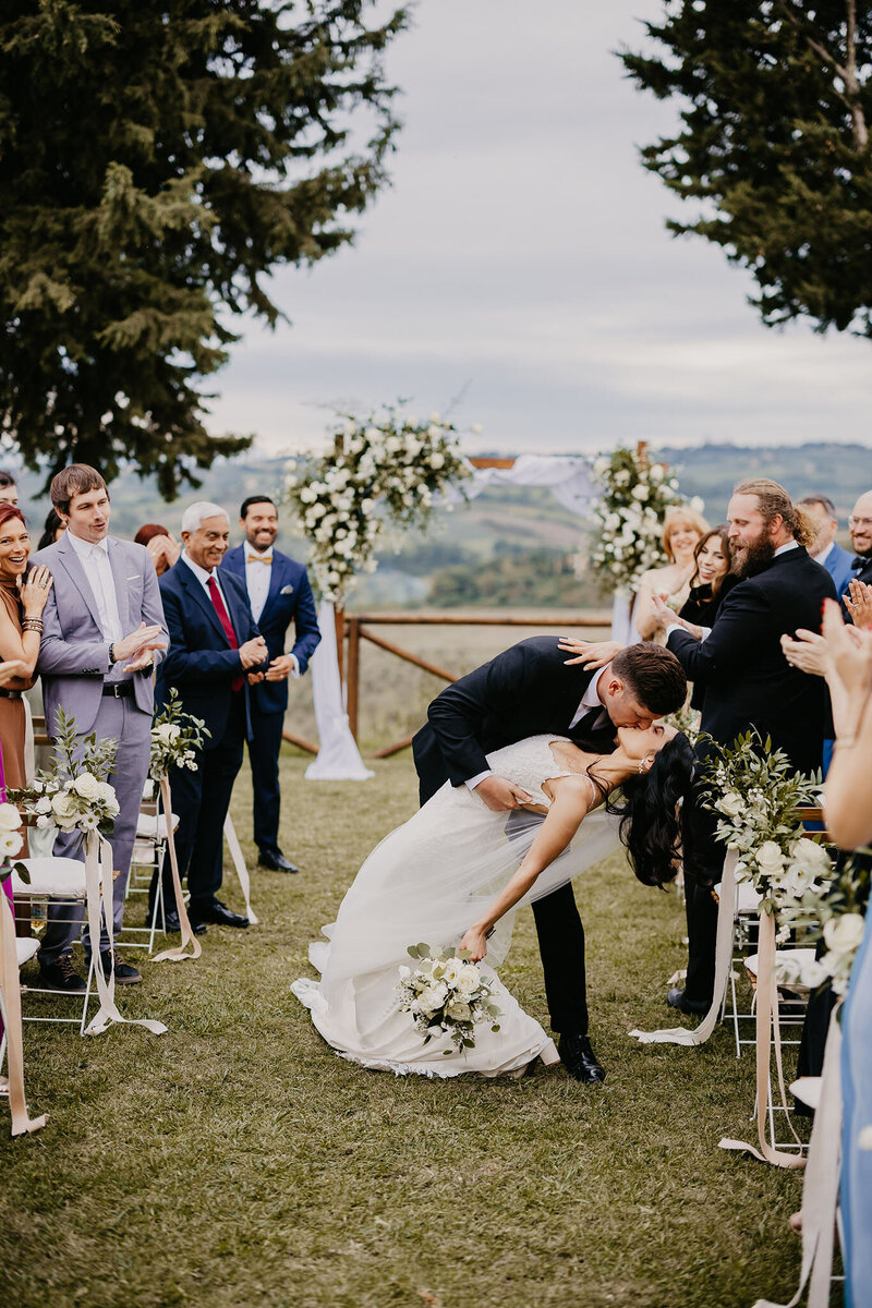 A couple kissing while doing the casquet after the civil ceremony at Borgo Divino