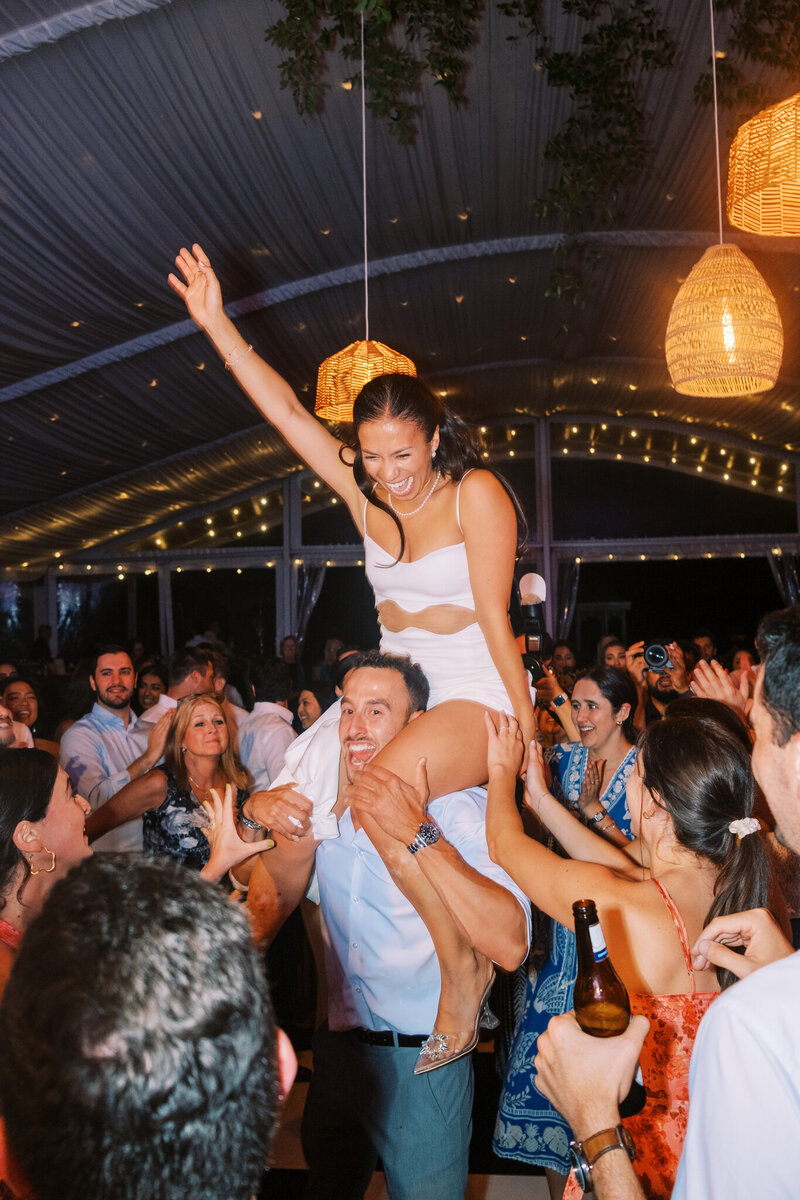 Bride on guests shoulders on dance floor during reception at Glen Foerd Estate