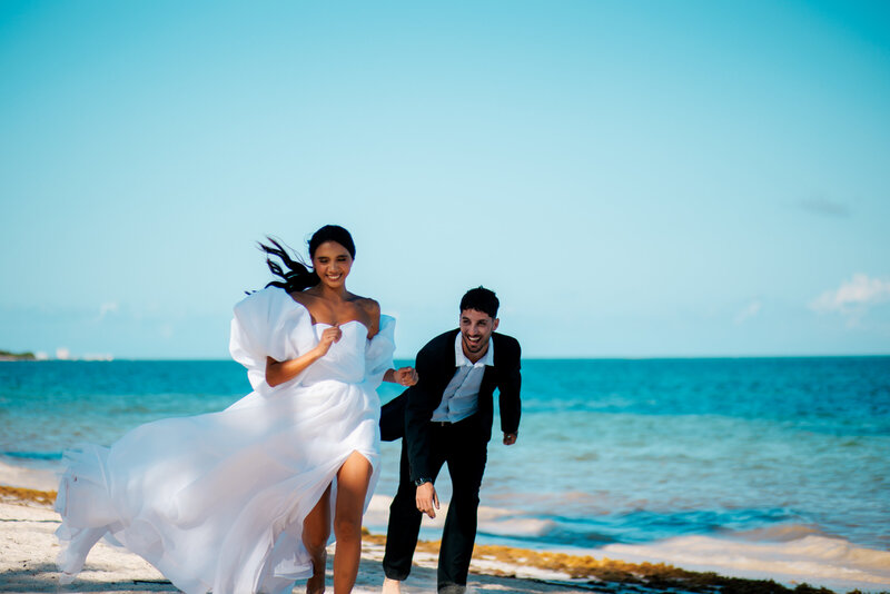 Bride-and-groom-running-on-a-Riviera-Maya_beach