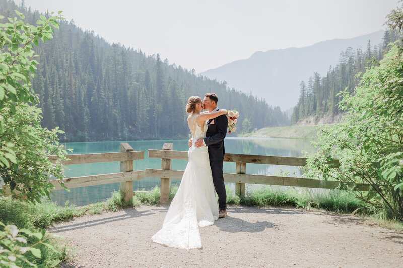 Couple with their arms around each other laughing and walking on a beach