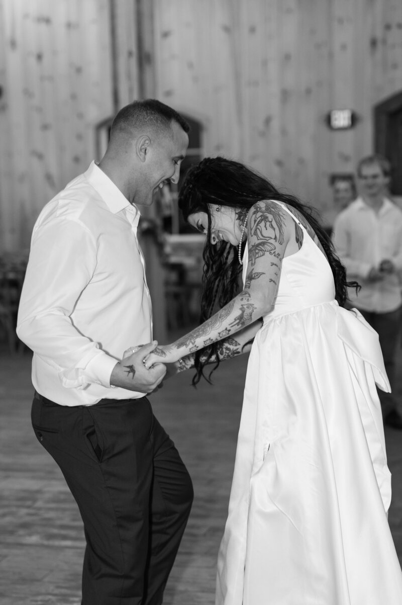 A newlywed couple dancing together and laughing