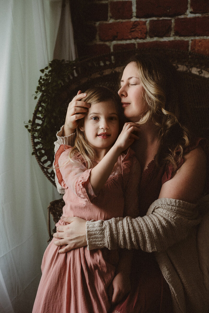 Toronto maternity photographer holding her young daughter on her lap