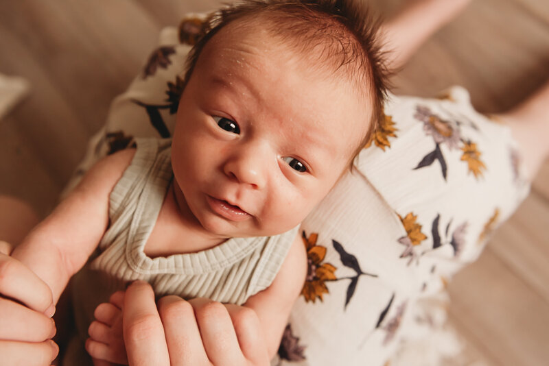 During his newborn photo shoot in the studio, a little one gazes up at the camera to show off his little expressions. 
