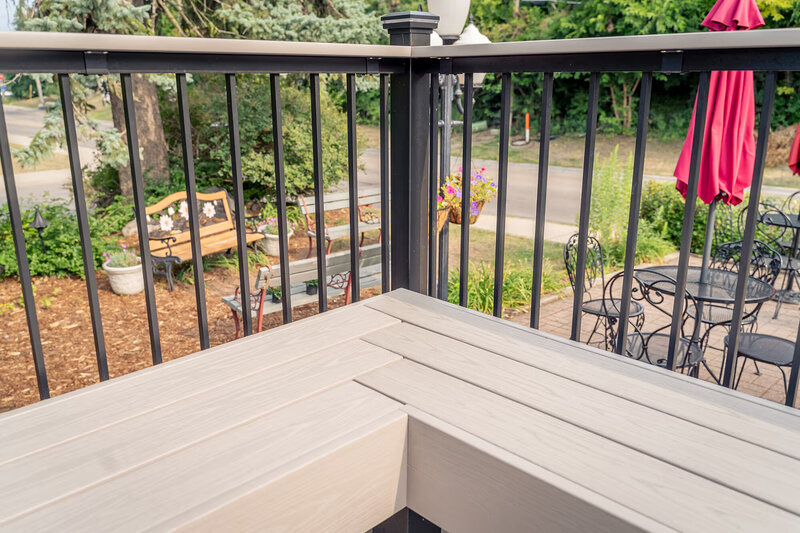 Corner view of built-in deck benches with a non-mitered design which gives the appearance of herringbone. 