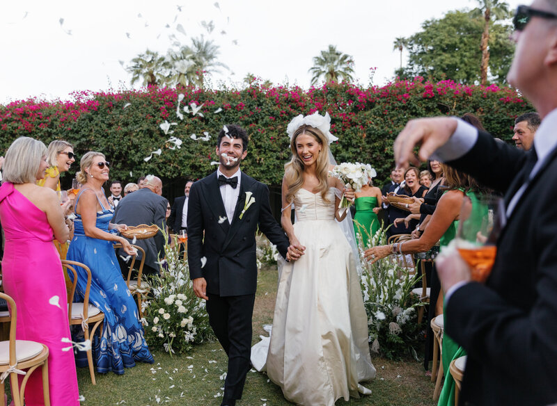 Bride and groom running down stairs on wedding day in Los Angeles