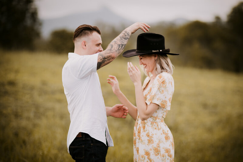 Man putting on his hat to her woman