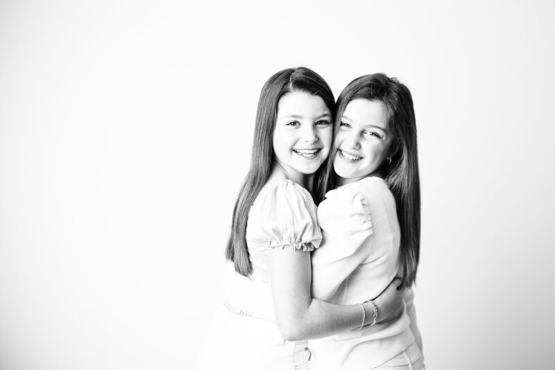 Adorable twin sisters photographed in timeless black and white, capturing their unique personalities and sibling bond in Canton, Georgia by Victoria Lee Photography.