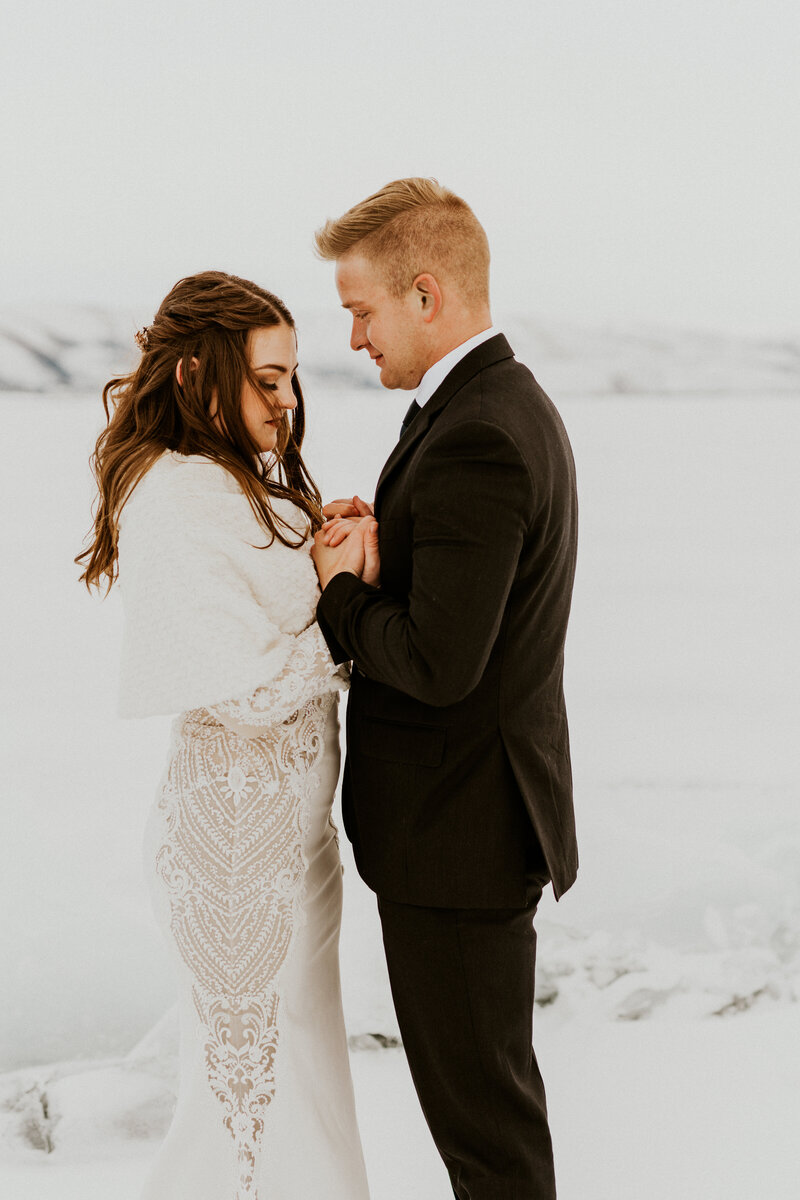 Couple sharing vows during their elopement on a frozen mountain lake in Alaska.