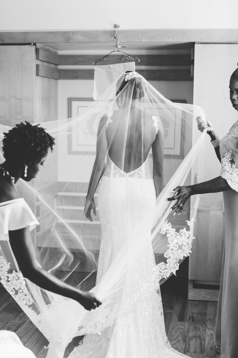 wedding party adjusts brides veil before ceremony
