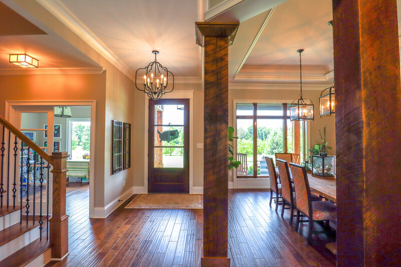 entryway with large wooden pillars and hard wood floors