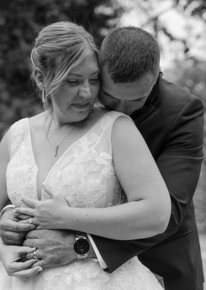 Bride and groom sharing a joyful, intimate kiss under the veil during their wedding ceremony