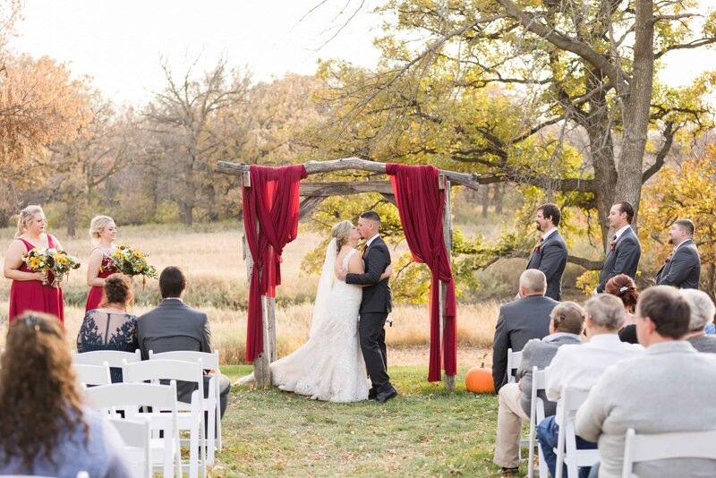 Bride and Groom sharing their first kiss at Rustic Oaks in Moorhead