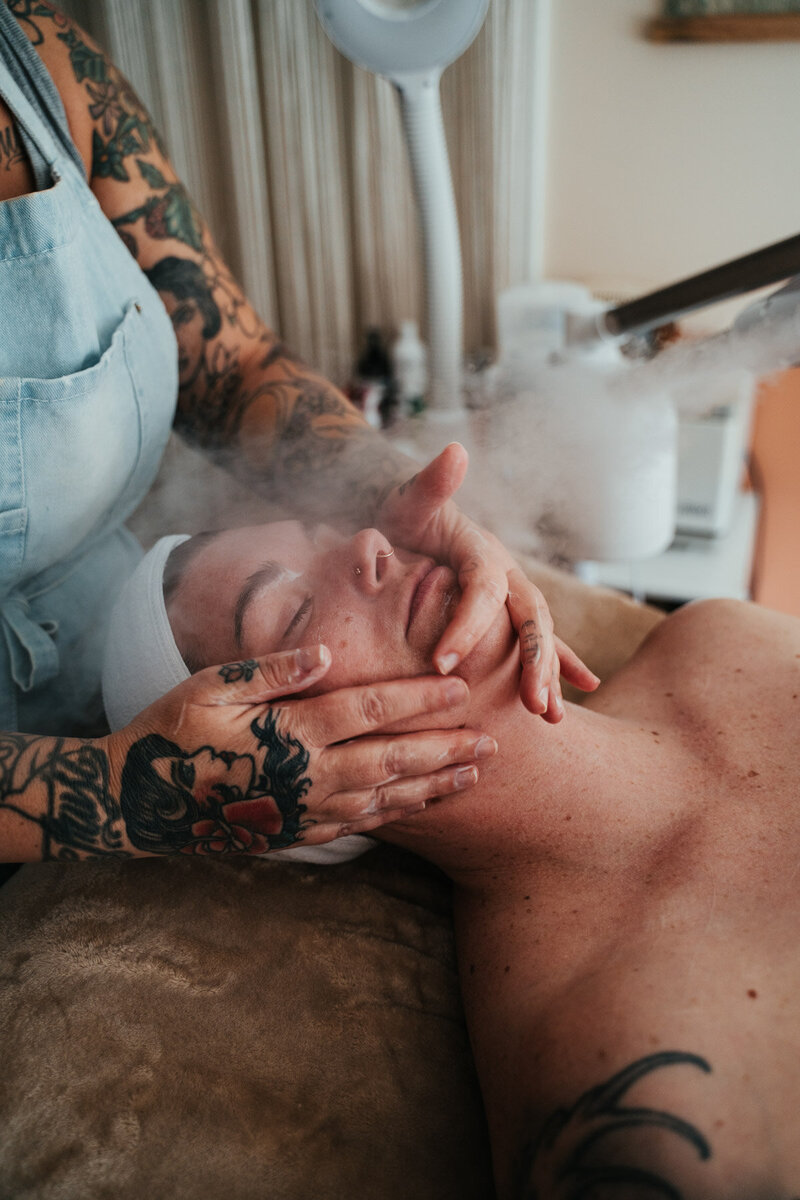 Libby's hands are on a client's face while providing a relaxing facial at her studio in Eugene. 