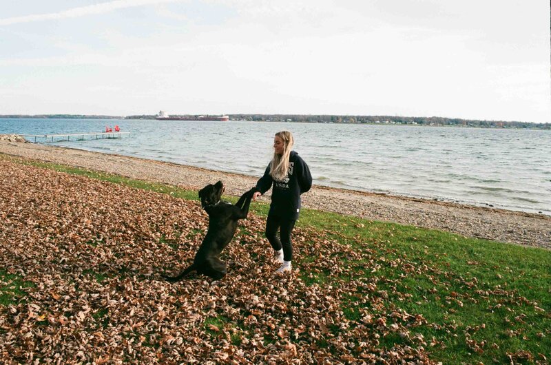 Sonia and her dog on a beach in fall