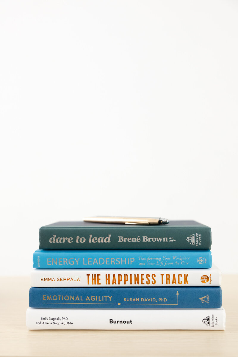 Stack of leadership and psychology books inspiring stress resilience and growth