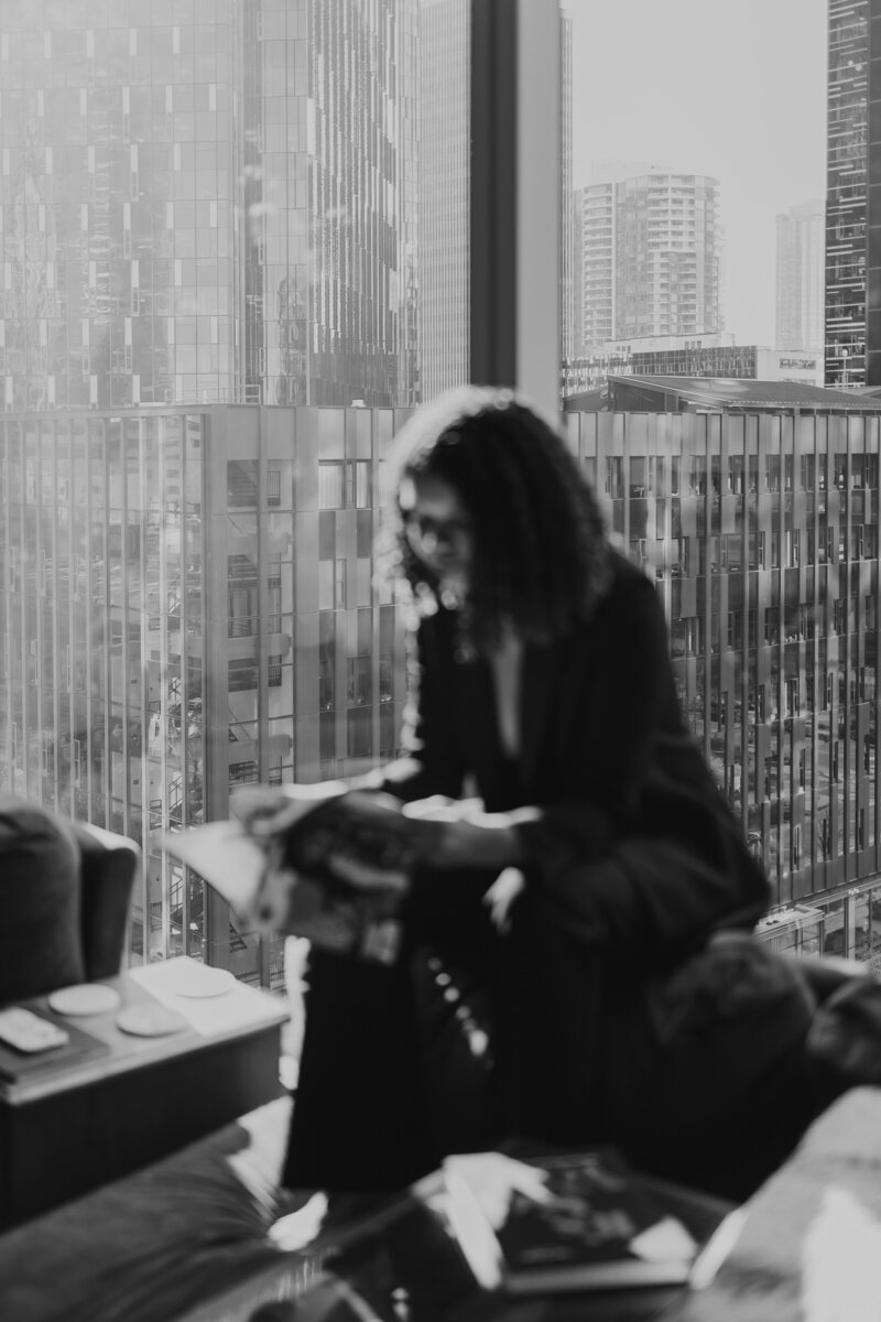 Blurry Black and White Photo of Catryce Looking at Magazine