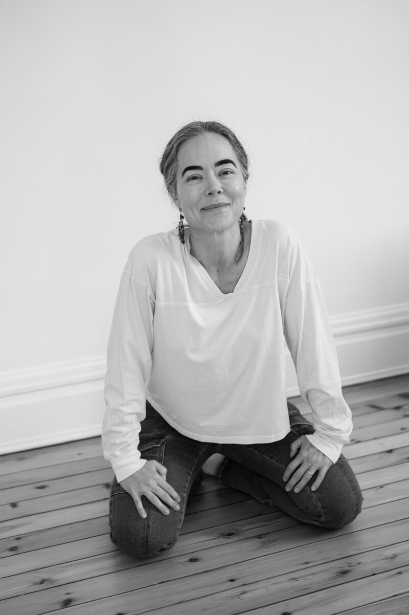 Dr. Tanner Wallace, founder of CPTSD Medicine, sitting on a wooden floor and smiling softly, representing calm self-awareness and healing from relationship red flags.