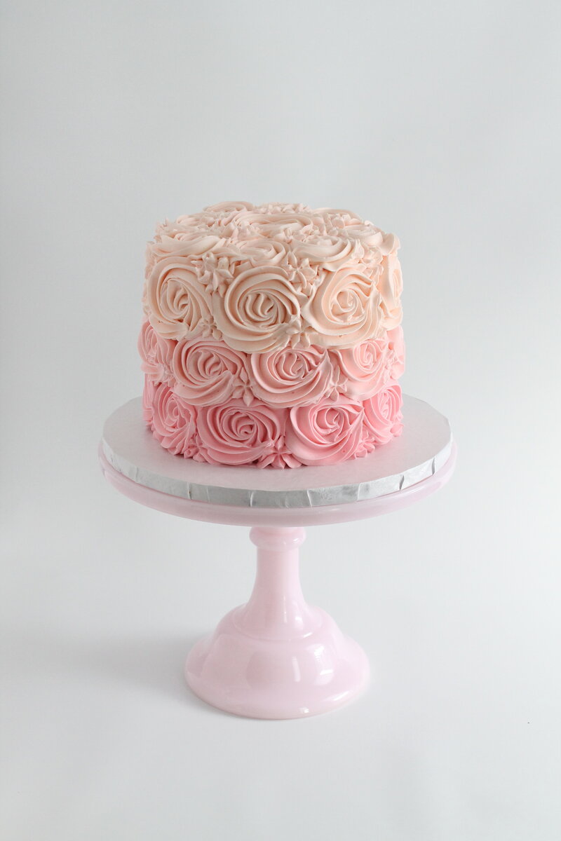 Pink cake with frosting and gold butterflies