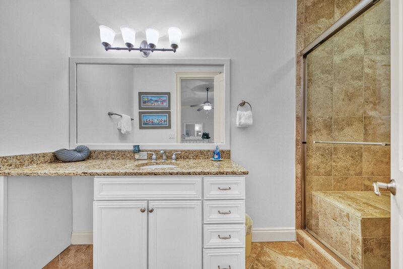 bathroom with granite counter top and walk in shower
