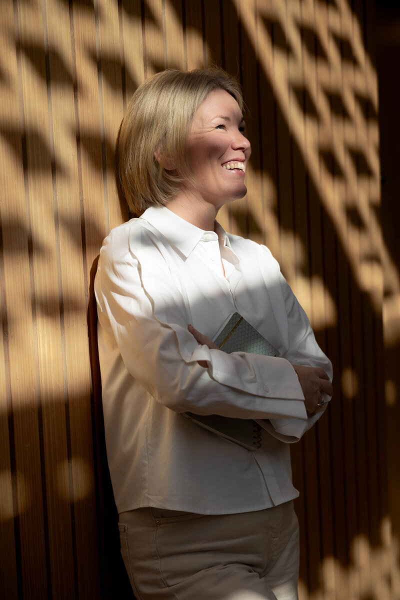 Portret Agnes Tuin met schaduw en licht tegen houten muur