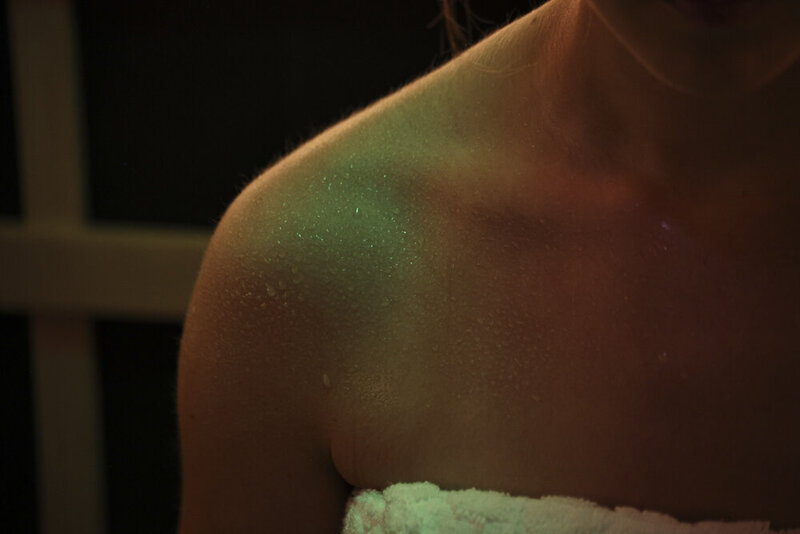 Woman's bare shoulder with sweat droplets