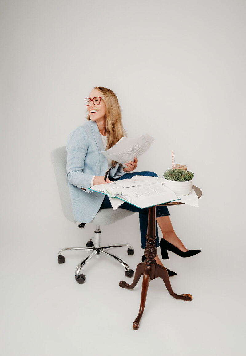 Rachel Toner, food sensory scientist and owner of Taste Strategy, sitting at a table with documents on the table in her hands